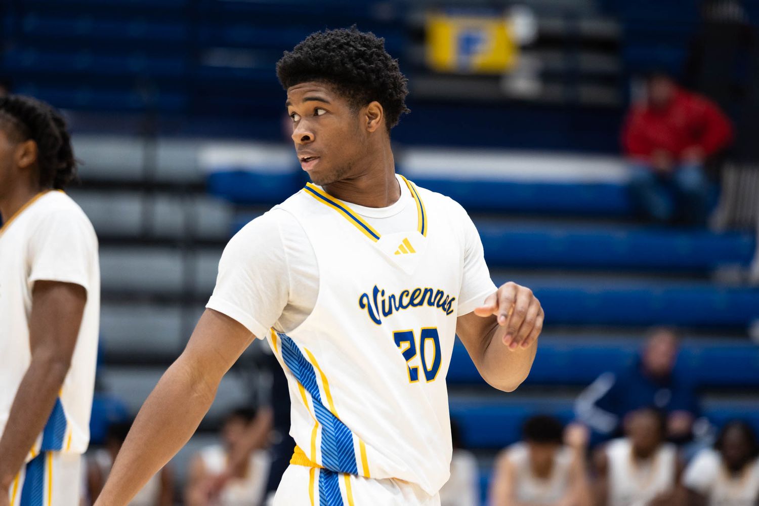 College basketball player number 20 in Vincennes uniform on the court during a game.