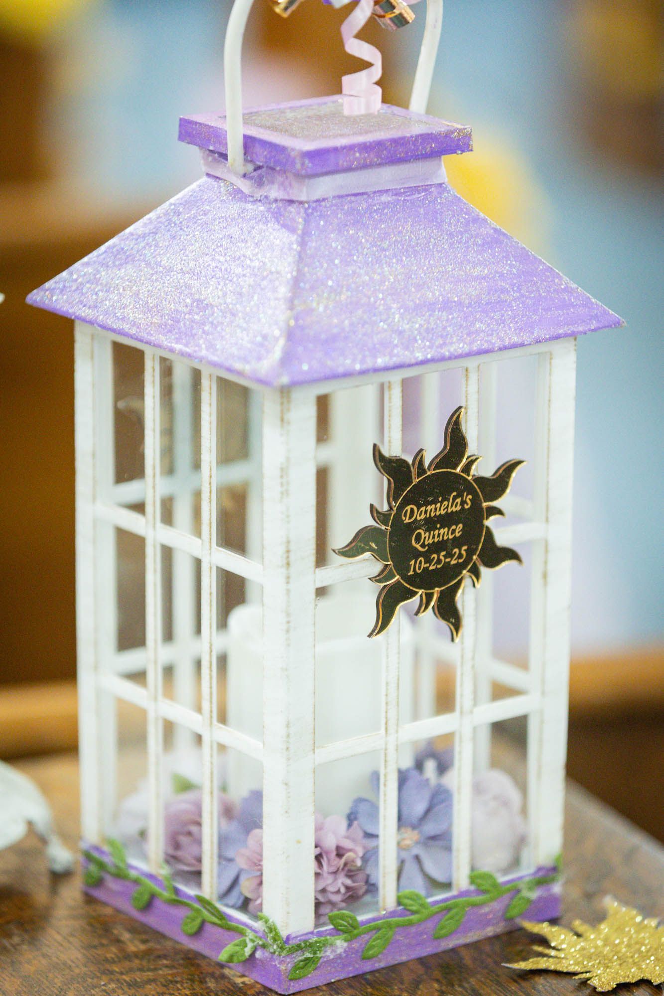 Purple and white decorative lantern centerpiece for Daniela's Quinceañera on 10-25-25 with floral accents.