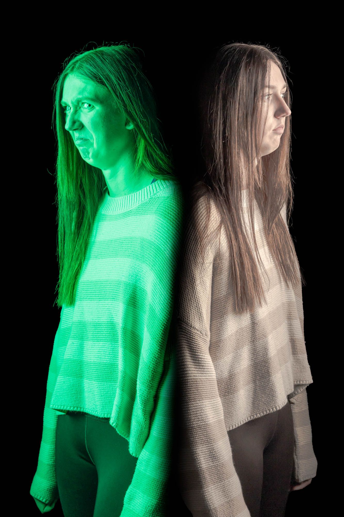 Woman photographed twice back-to-back under green and white lighting against dark background showing two expressions.