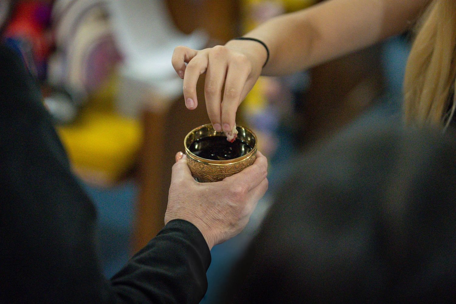 Hands reaching into small bowl of berries at celebration event.