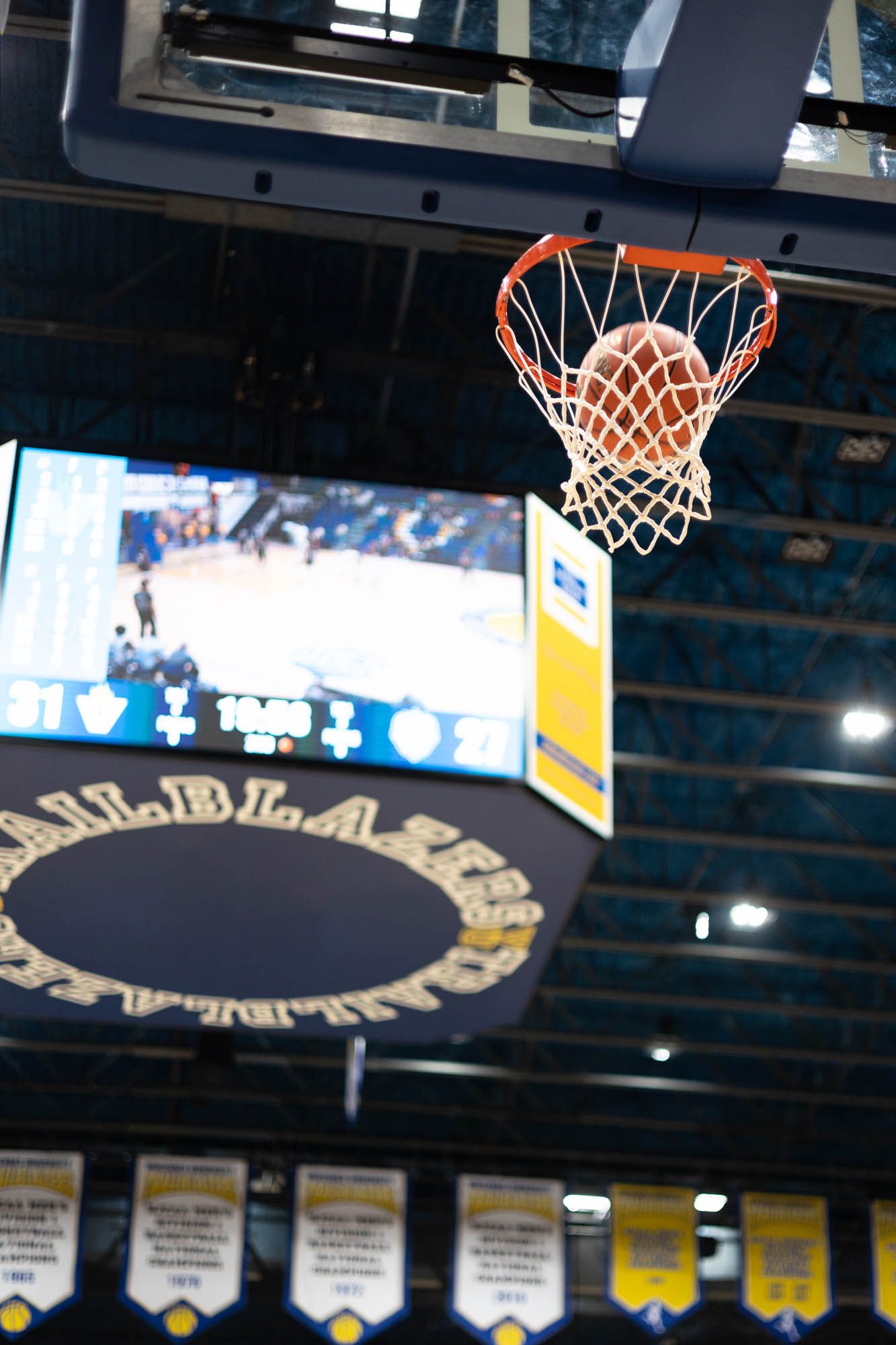 Basketball passing through the hoop net at Vincennes University Trailblazers indoor arena.