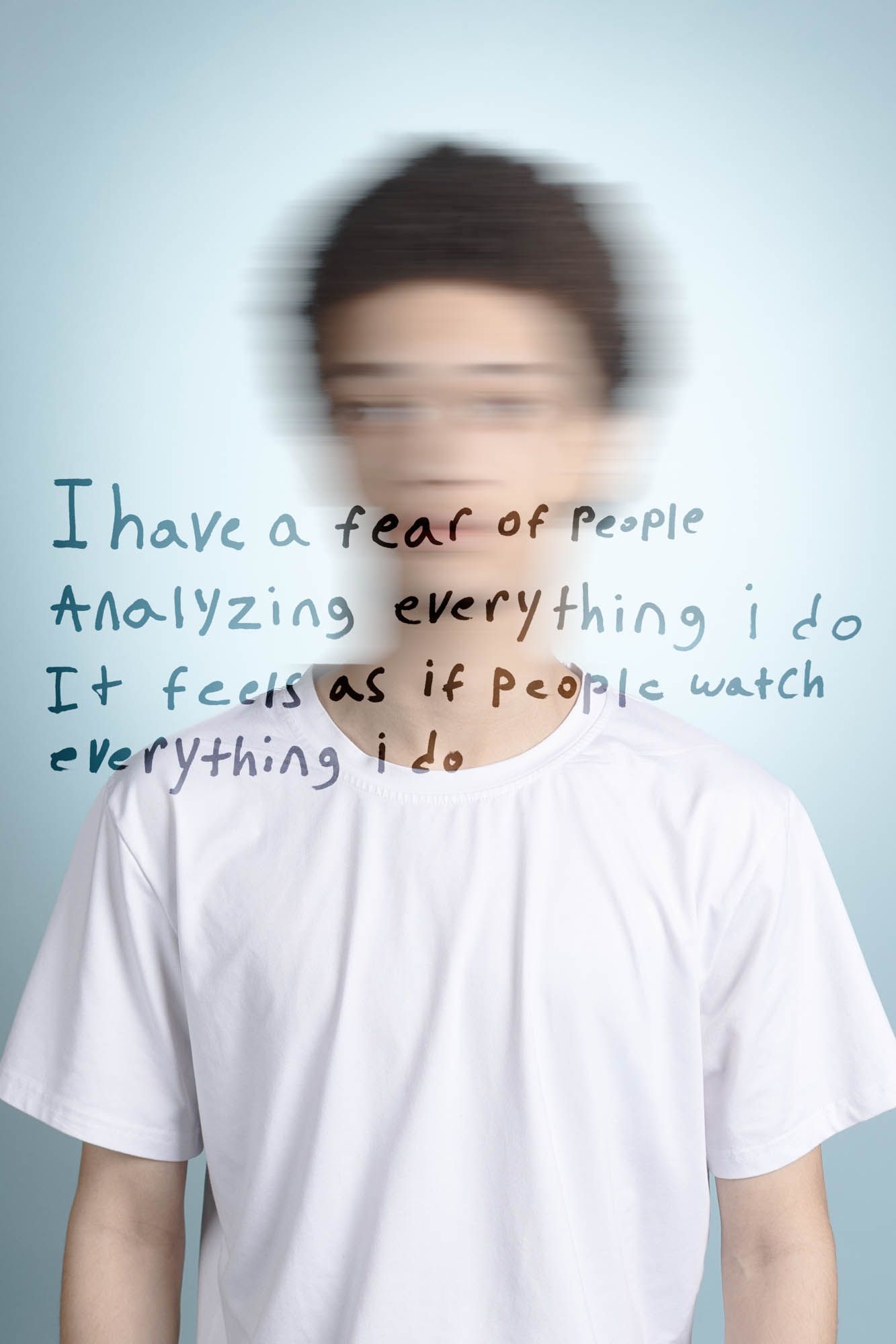 Blurred face of young person in white t-shirt with text about fear of being watched and analyzed by others.