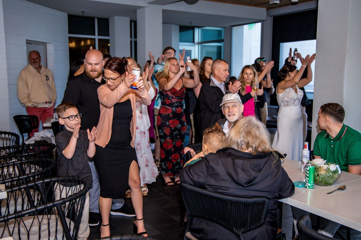 A panoramic view of a crowded party or event space with people mingling and socializing in a modern indoor setting.