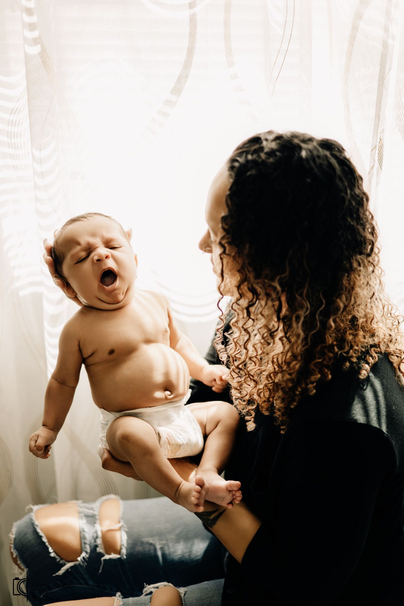 A series of three artistic black and white photographs showing someone holding a baby doll in different poses.