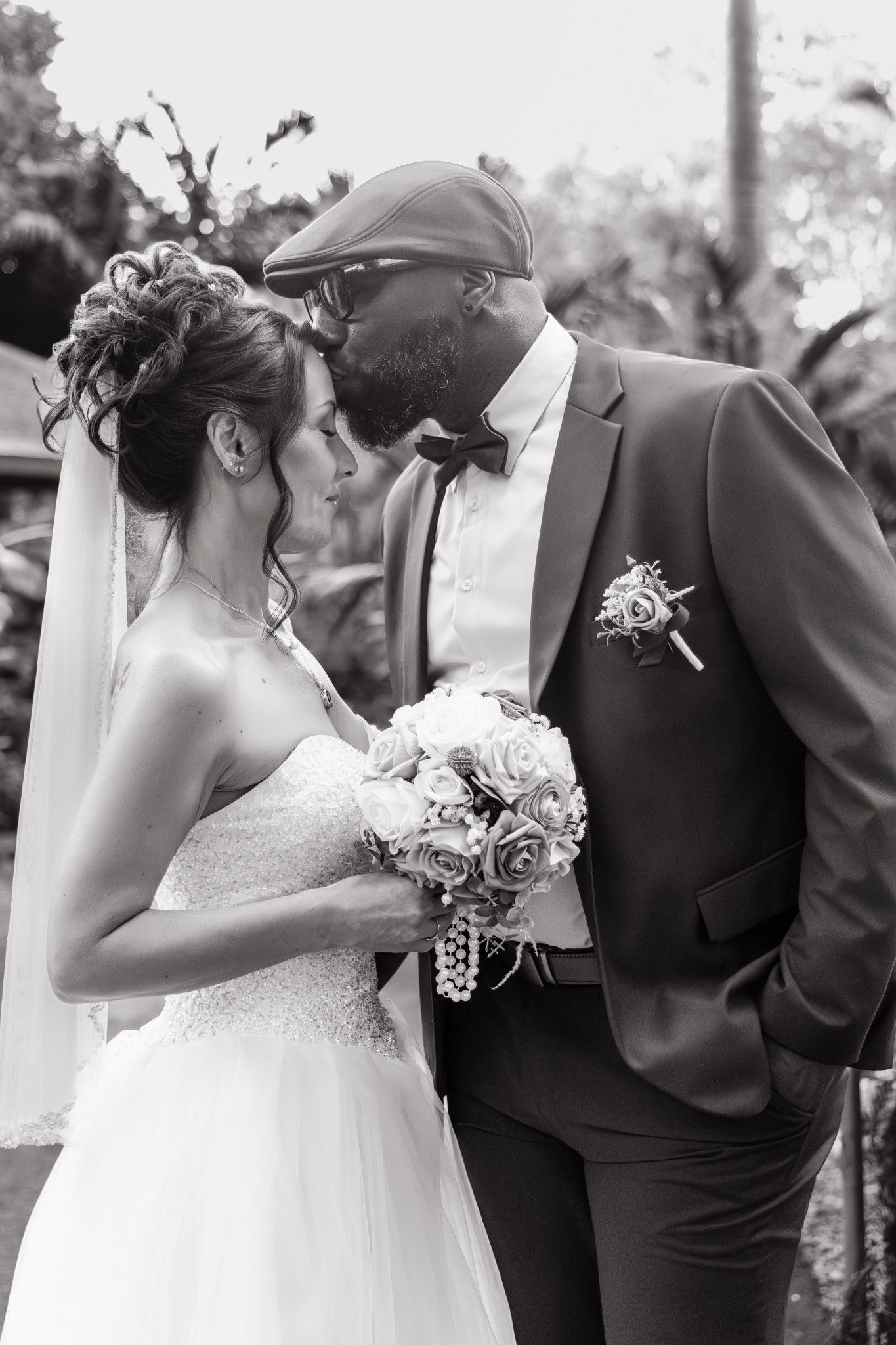 A romantic black and white wedding photo series showing tender moments between a bride and groom in formal attire.