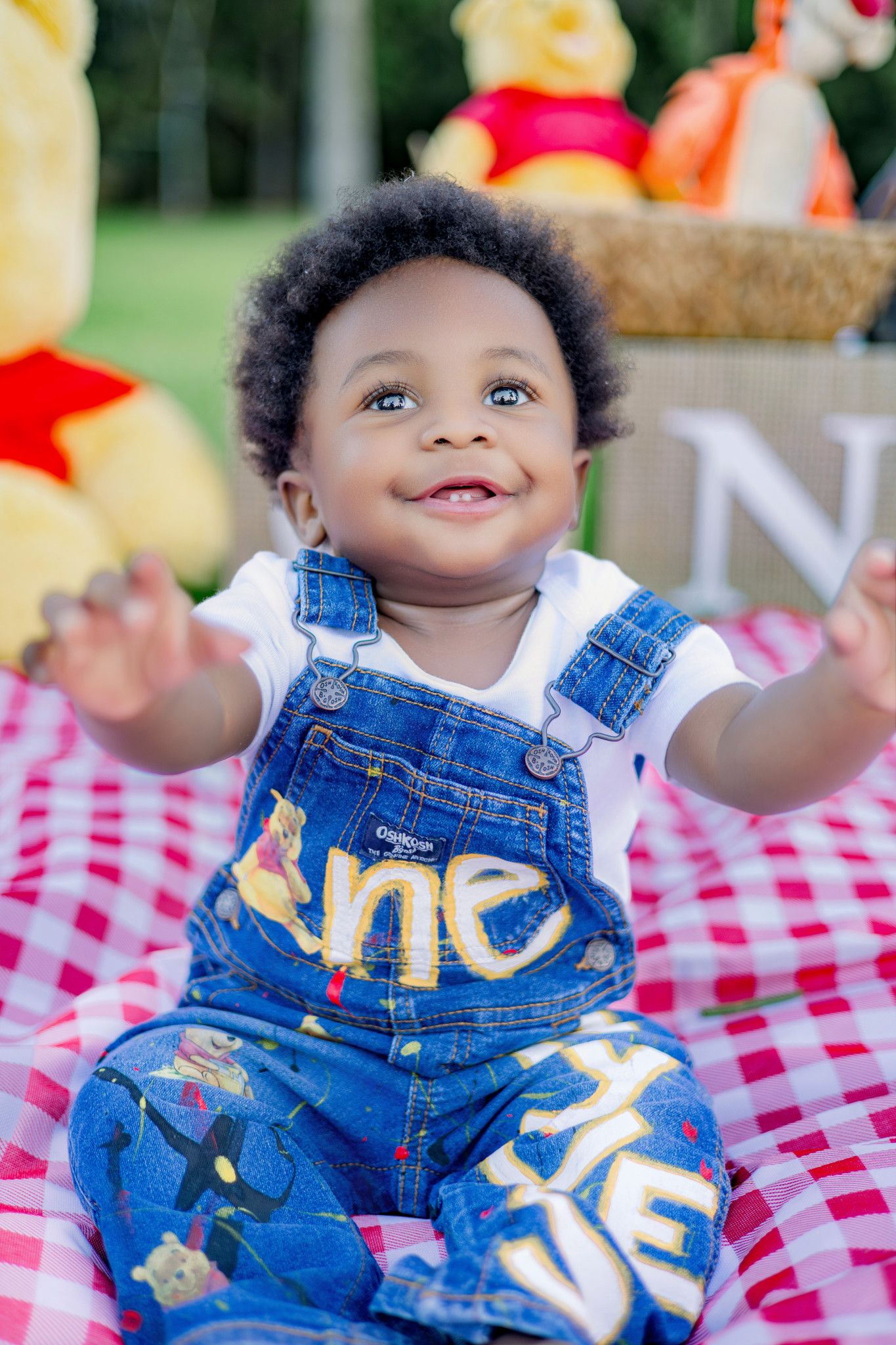 Smiling baby in denim overalls with \