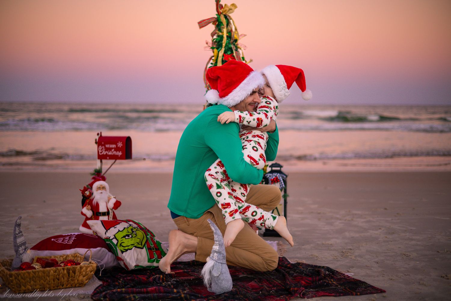 Person in green elf costume and red bow proposes on beach at sunset with Christmas decor and Coca-Cola bottle.