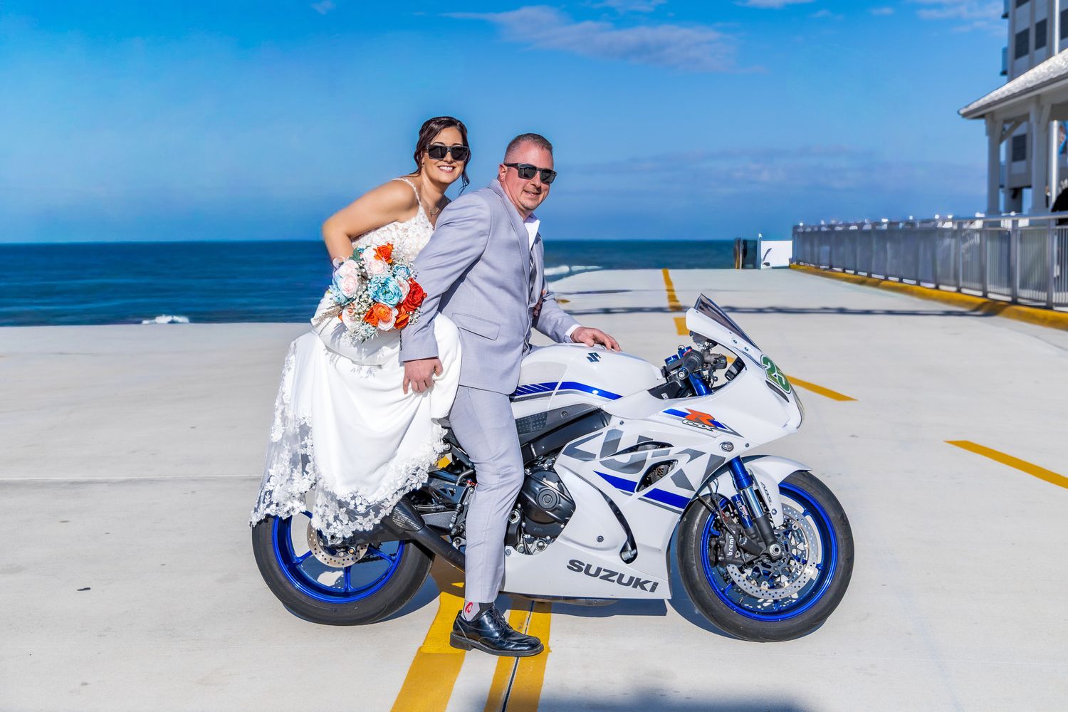 A blue and white sports motorcycle parked at a sunny beach with multiple action shots showing different angles and poses.