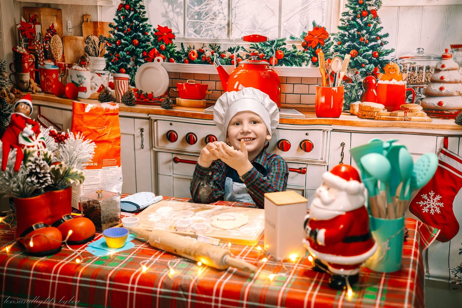 A festive Christmas kitchen decorated with trees, plaid tablecloth, and red and turquoise holiday decor.
