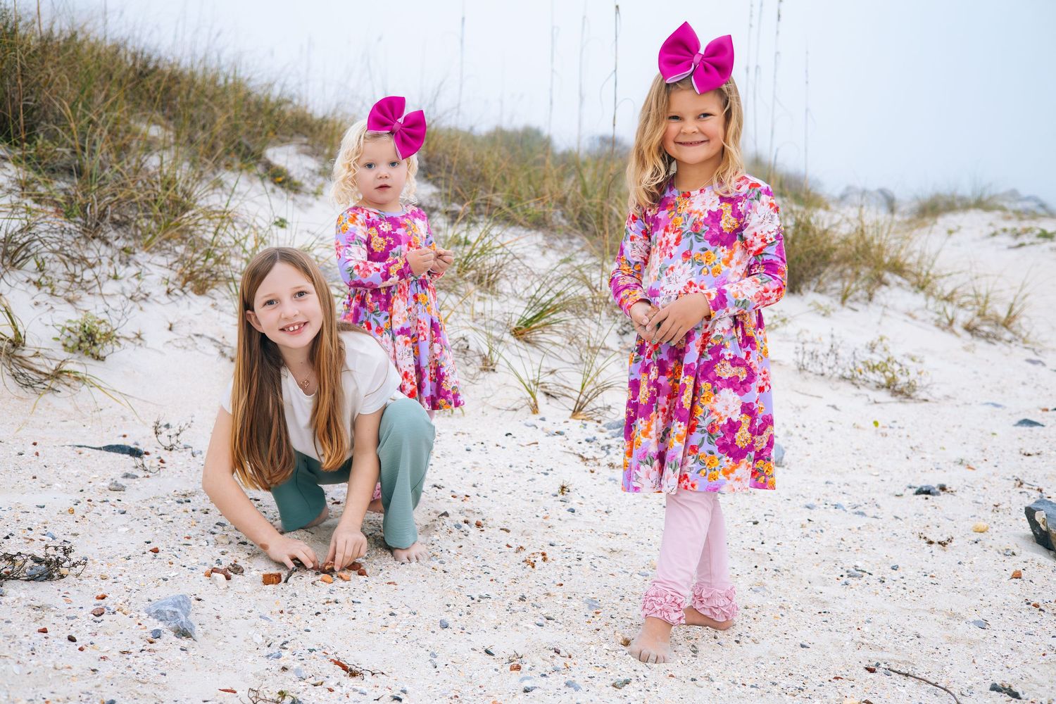Five beach photography images showing someone posing in casual attire with pink floral accents against white sand dunes.