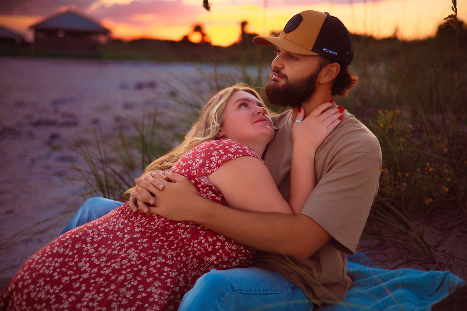 A couple shares an intimate moment at sunset on the beach.