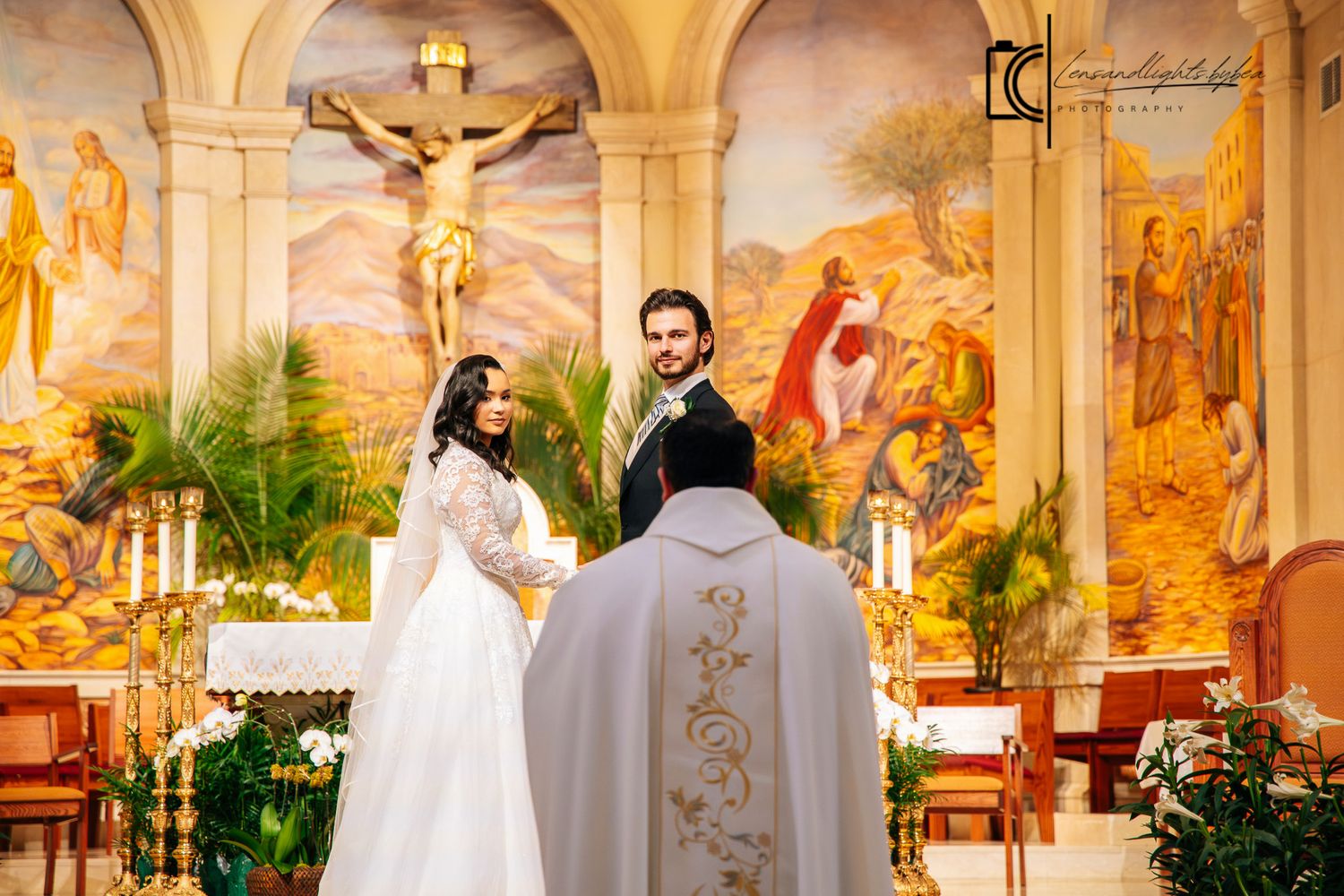 Bride and groom exchanging vows before priest at decorated Catholic church altar.