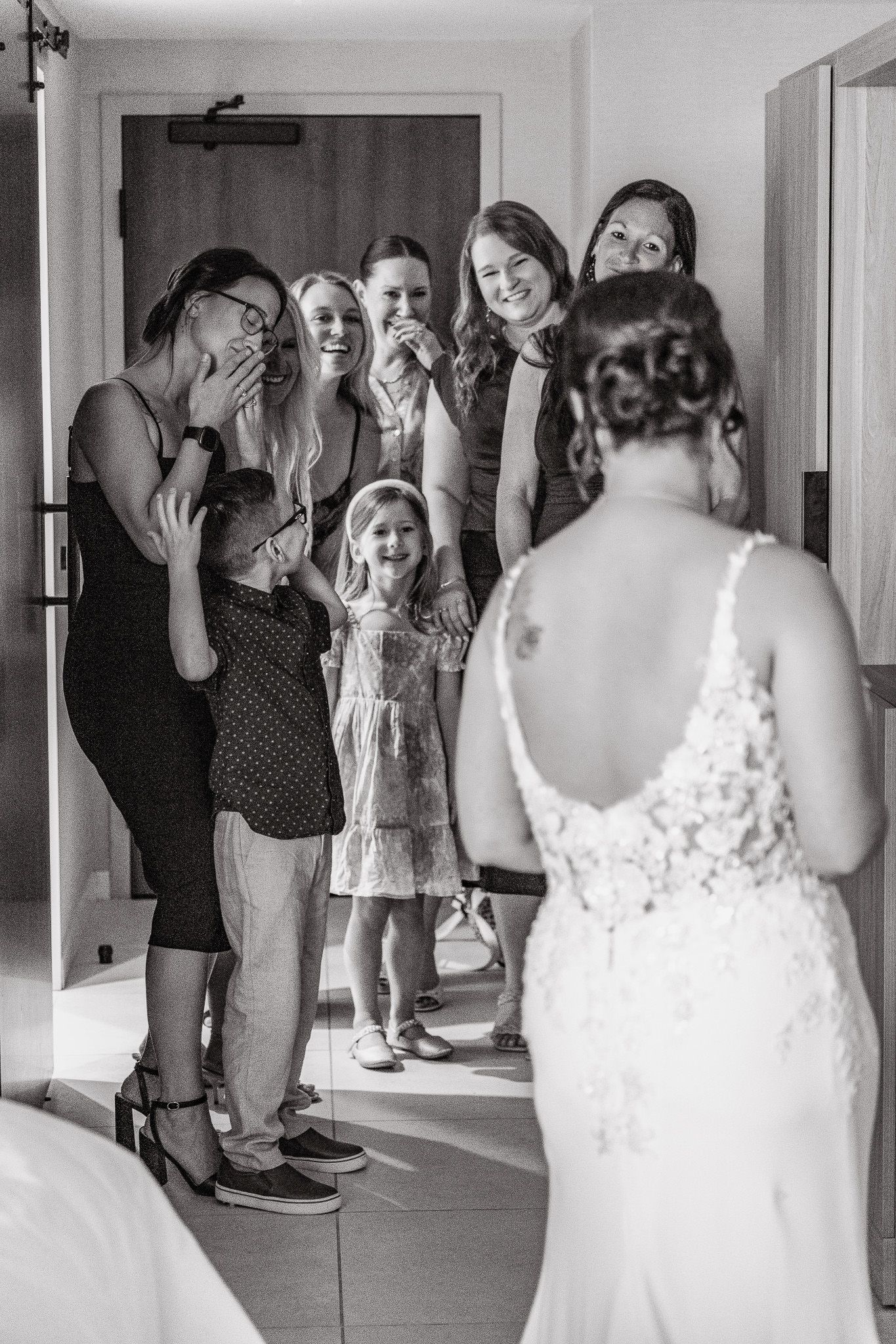 A sequence of black and white photos showing a group reacting with joy and excitement during a wedding preparation.