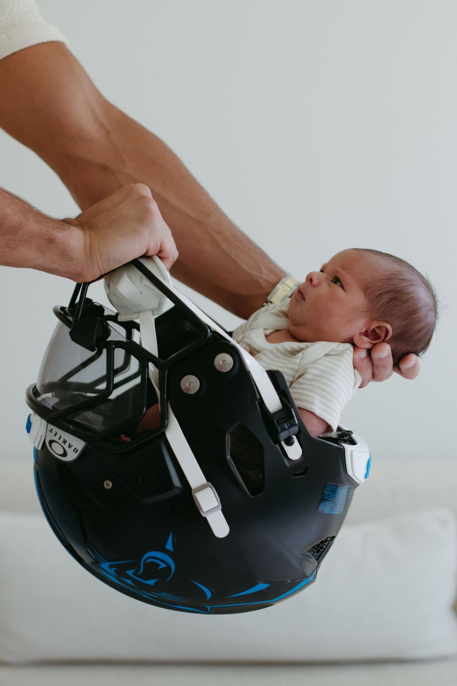 NFL player from the Carolina Panthers cradling his newborn in a candid family moment