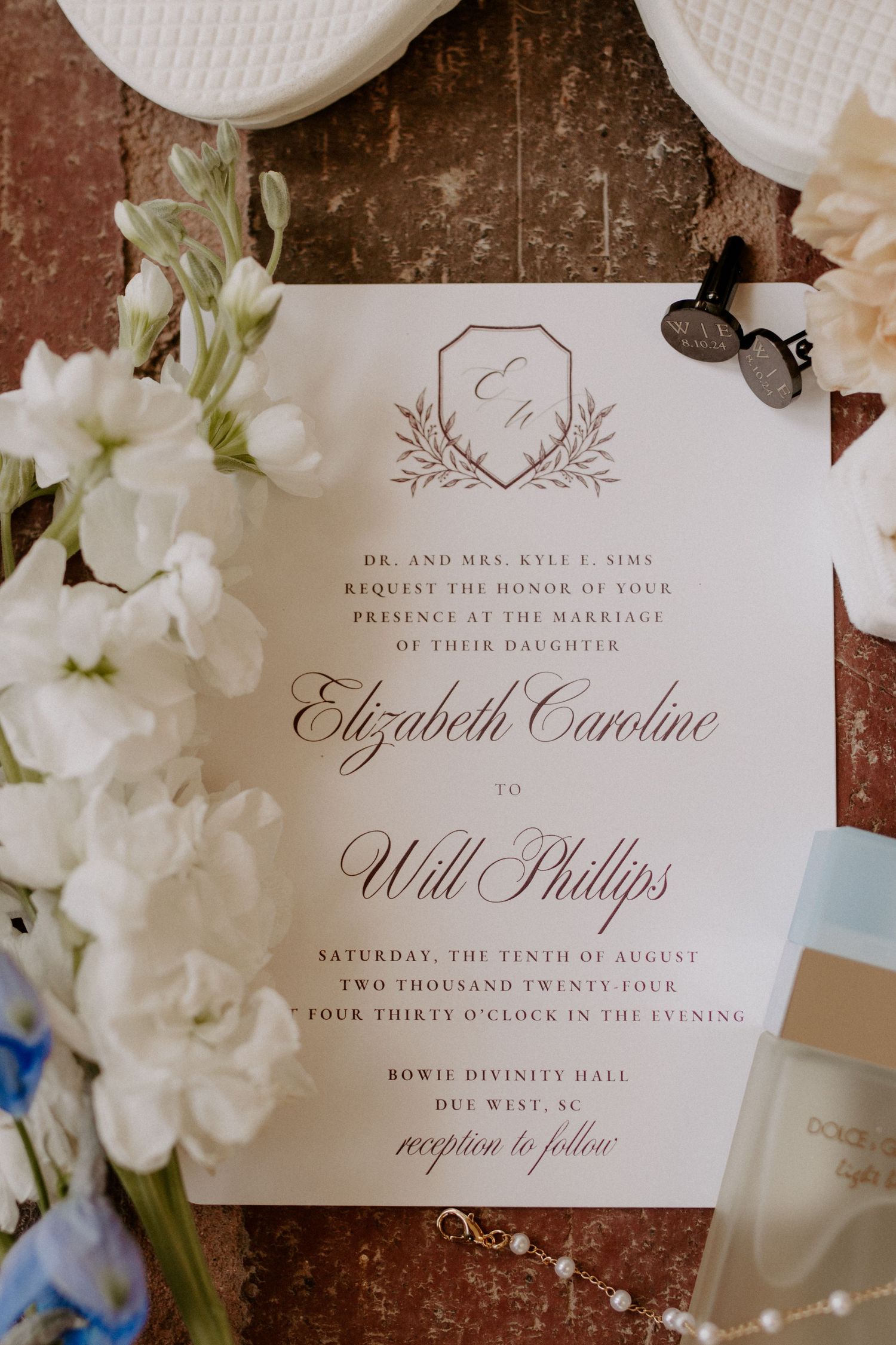 Flat lay of wedding rings, bouquet, and invitation suite