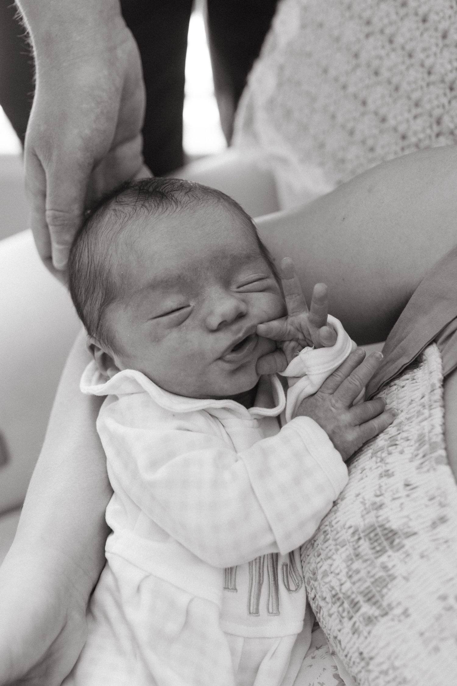 Close up of a sleeping newborn in parent’s hands