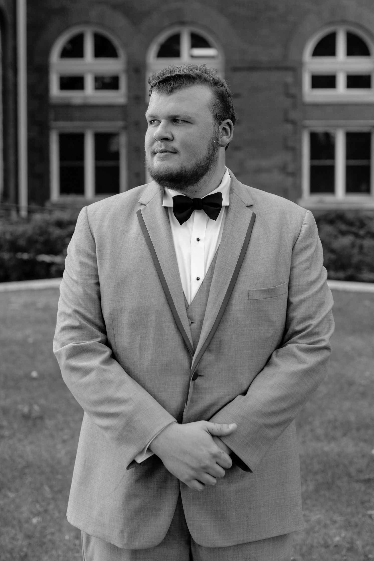 Groom standing outdoors in his wedding suit