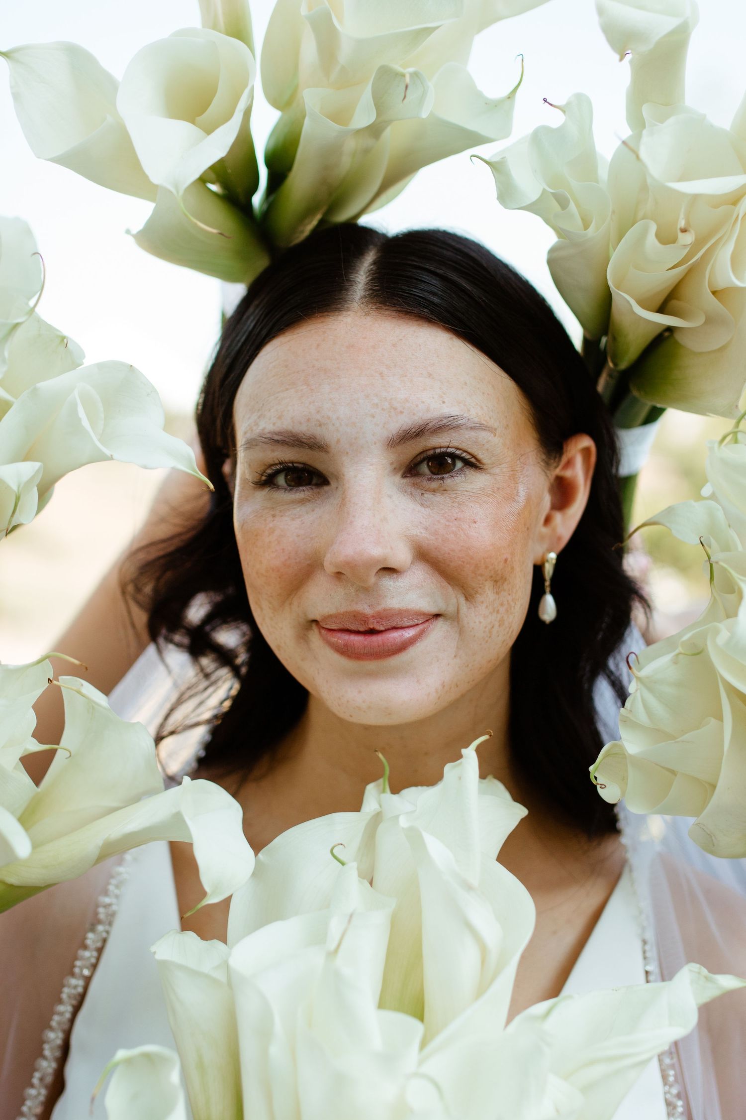 bride with bouquet around her face