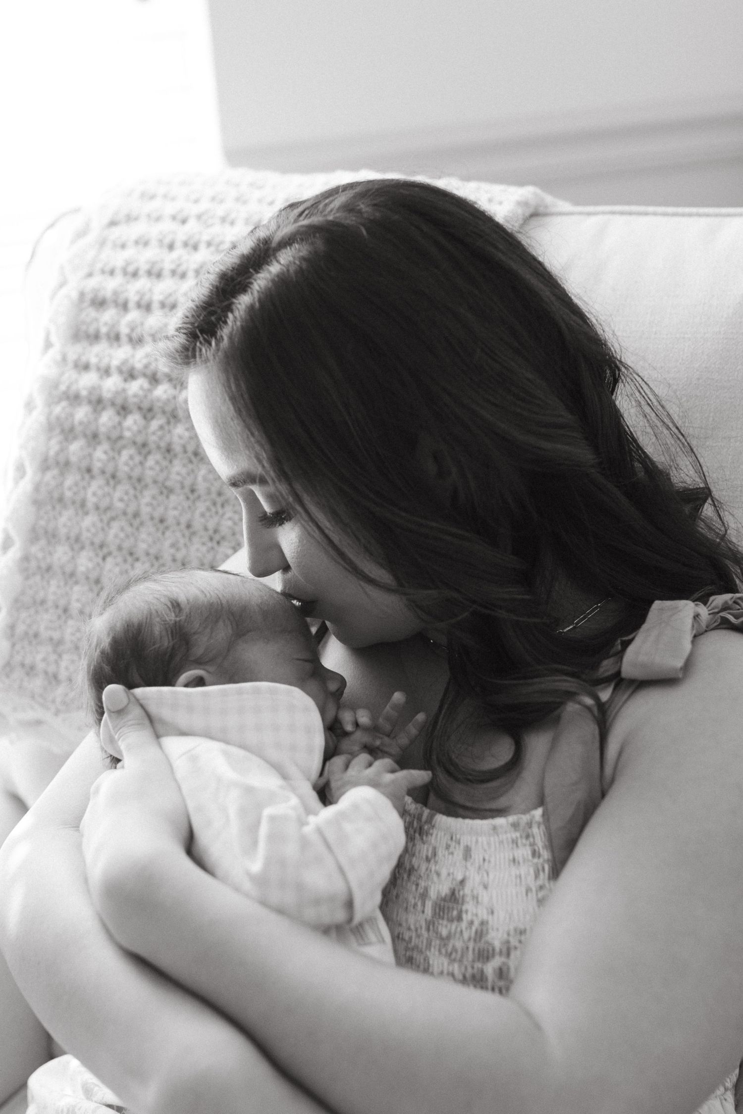 Mother gently holding her baby during a lifestyle newborn session