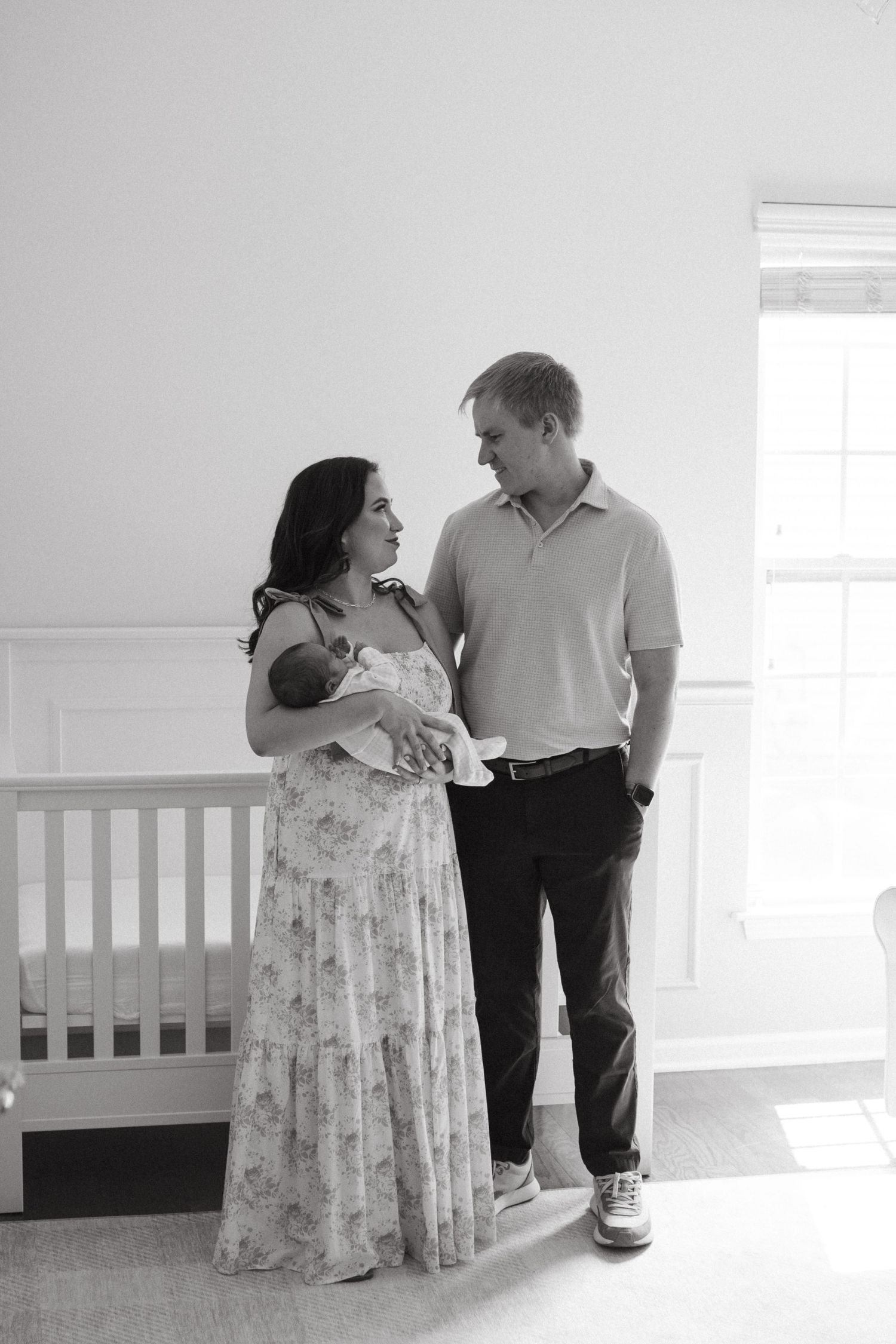 Parents gently holding their newborn baby together