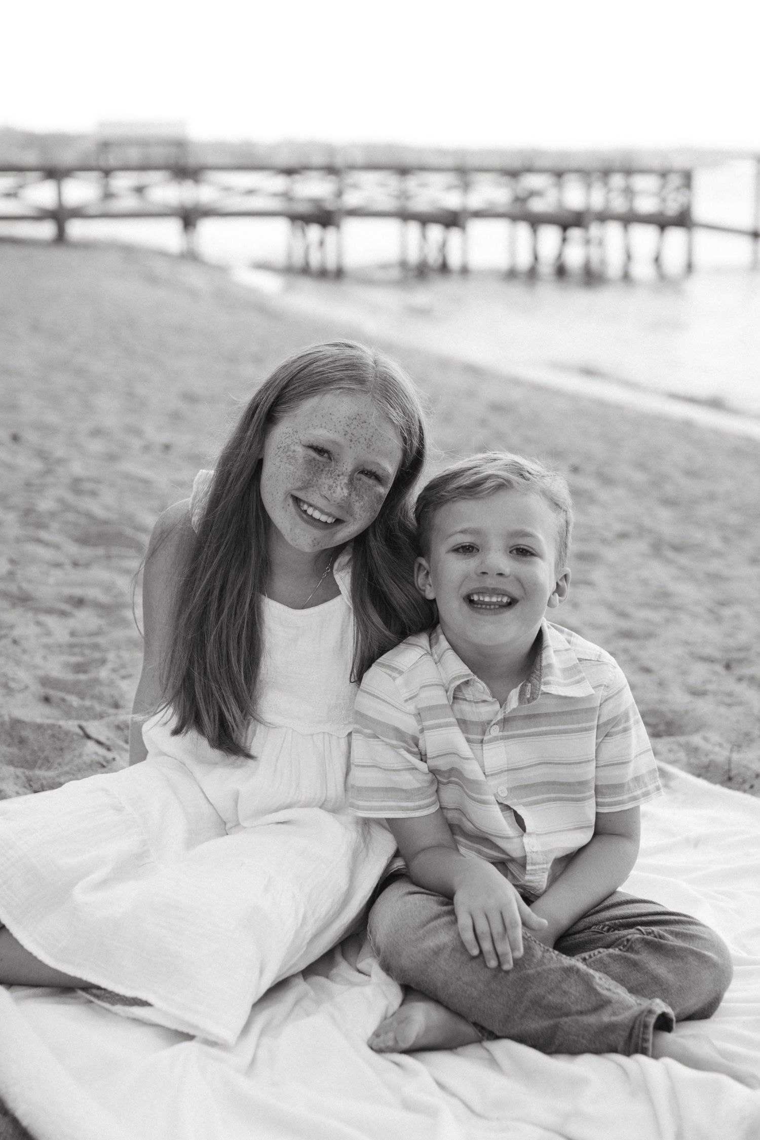 Siblings hugging and smiling together during a family session