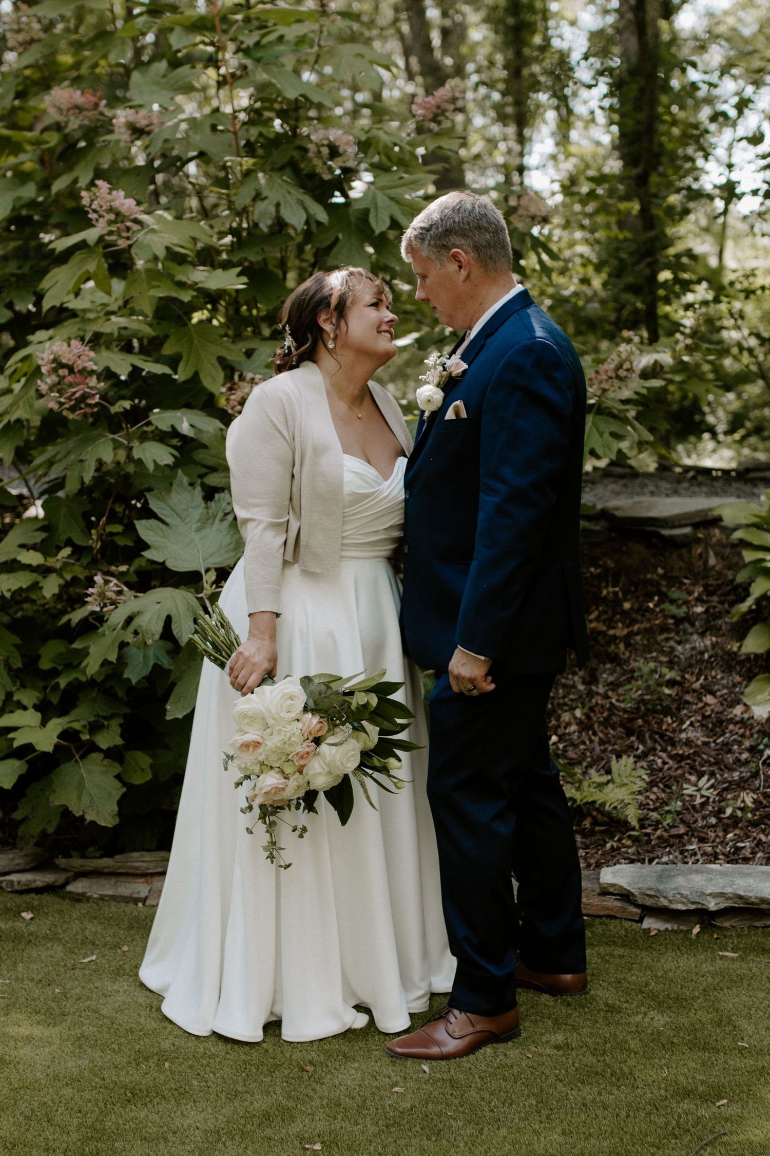 Bride and groom sharing a romantic moment during their outdoor summer wedding