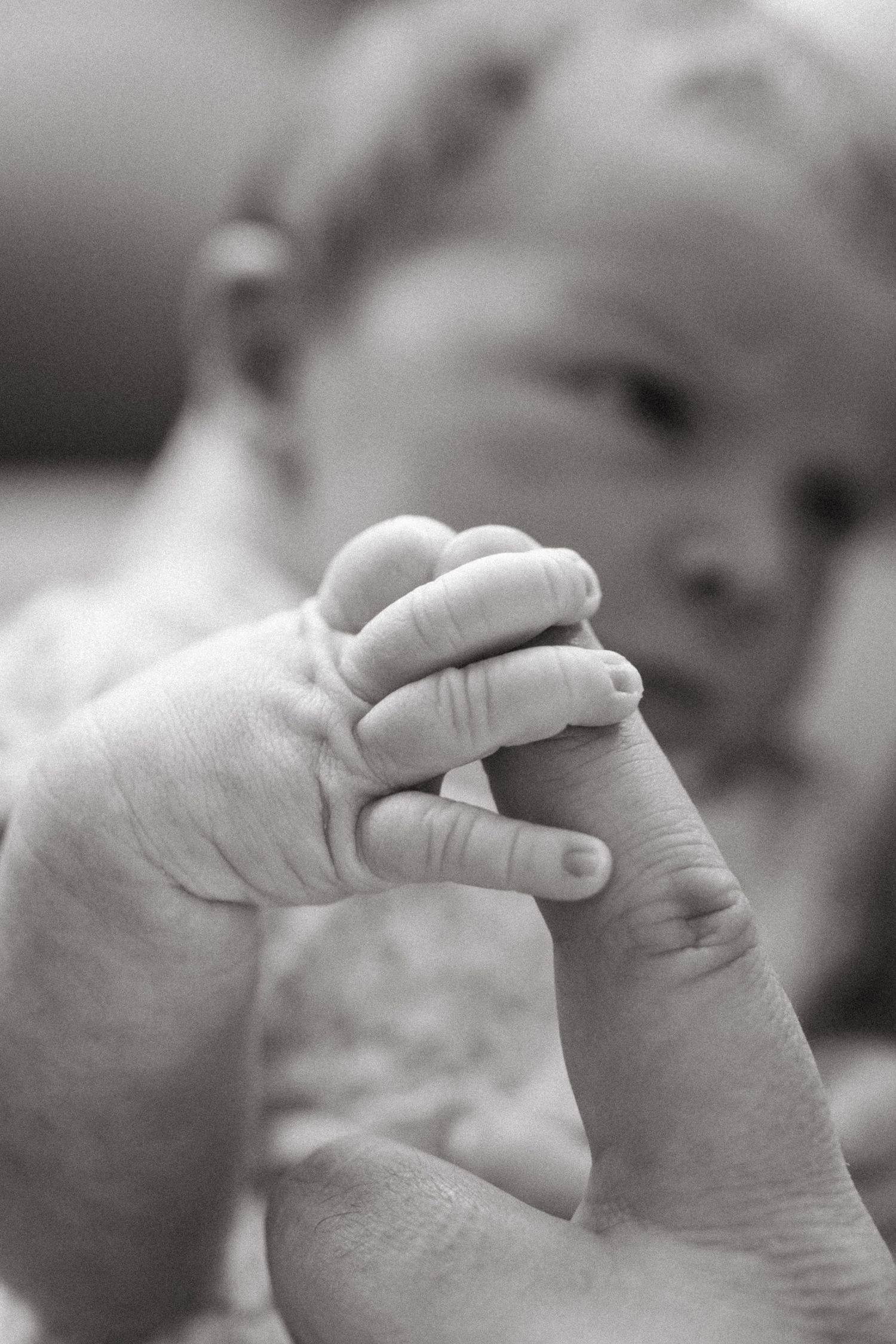 newborn holding parents finger
