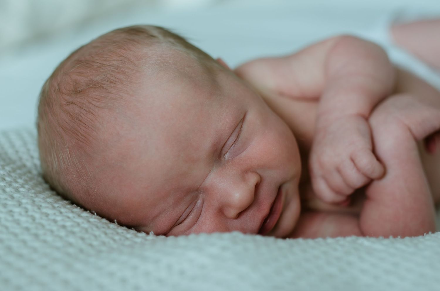 a sleepy newborn posing for a charlotte newborn photo session