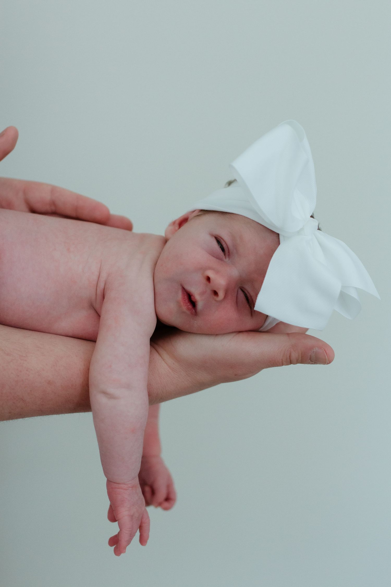 newborn baby sleeping in parent's hand