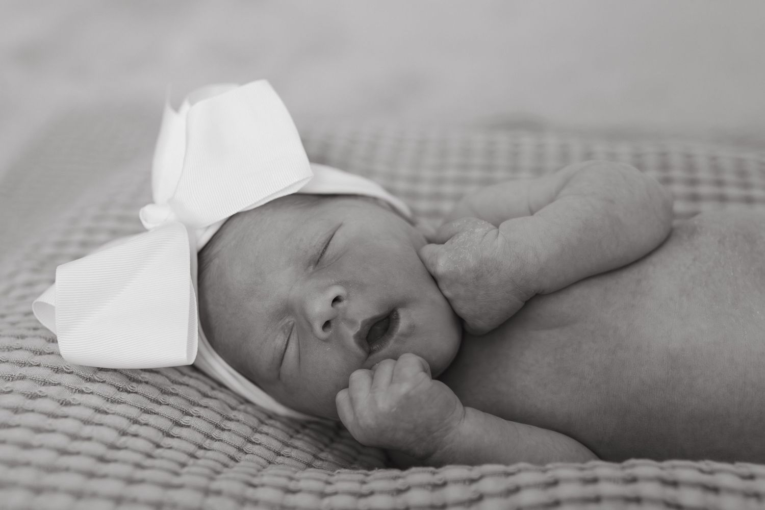 Lifestyle newborn photo of baby resting in hospital bassinet