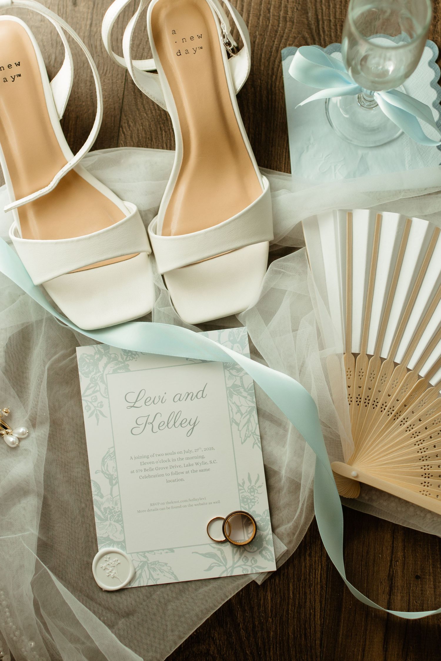 Flat lay of wedding rings, bouquet, and invitation suite