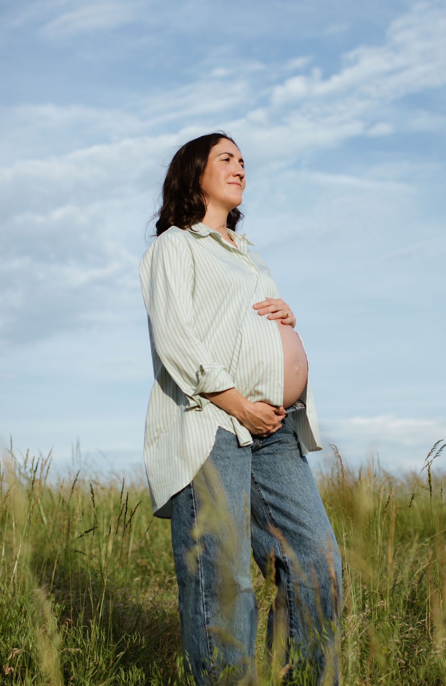 a mother-to-be cradling her baby bump during an outdoor maternity session in charlotte nc