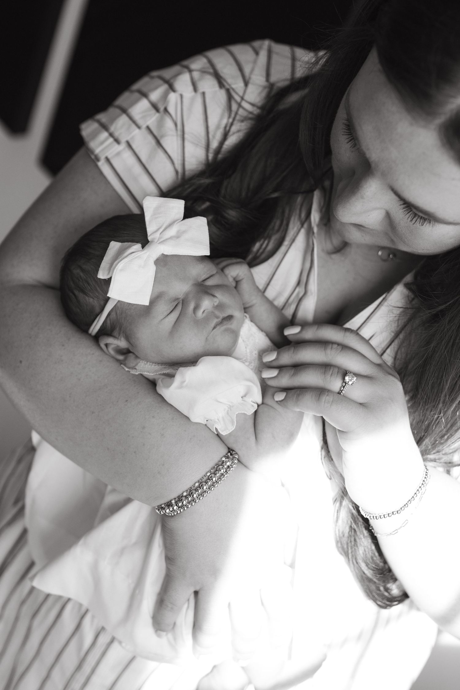 Emotional bonding moments between mother and her newborn baby during an in-home newborn session