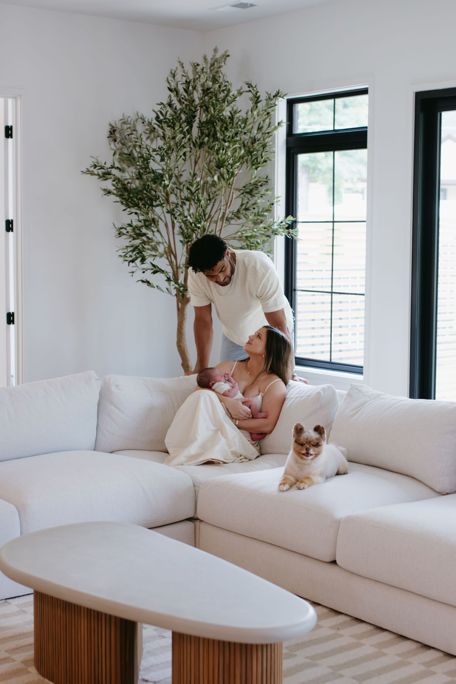 parents holding newborn baby on couch during newborn session