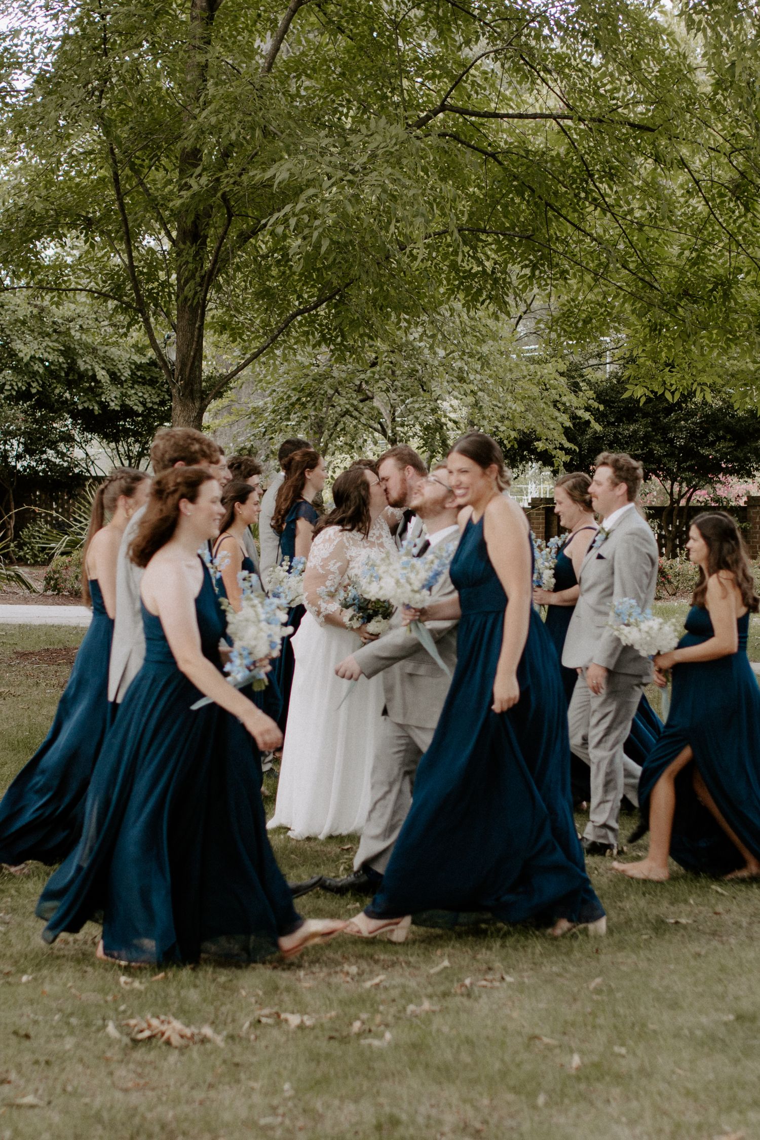 Bride and groom posing with bridesmaids and groomsmen outdoors