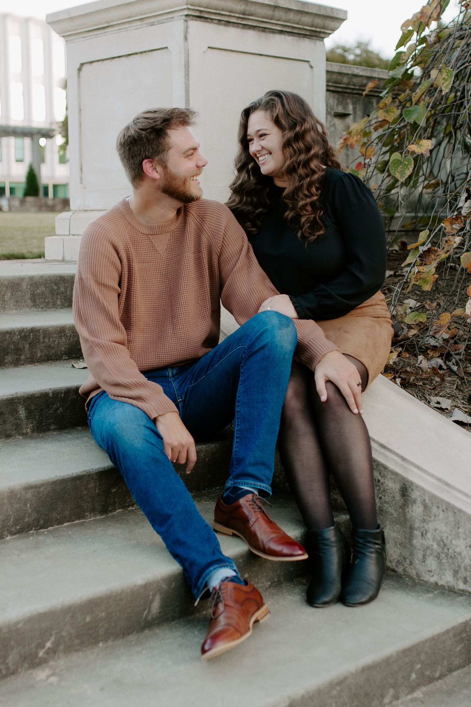 couple sitting in the park on stairs in charlotte north carolina