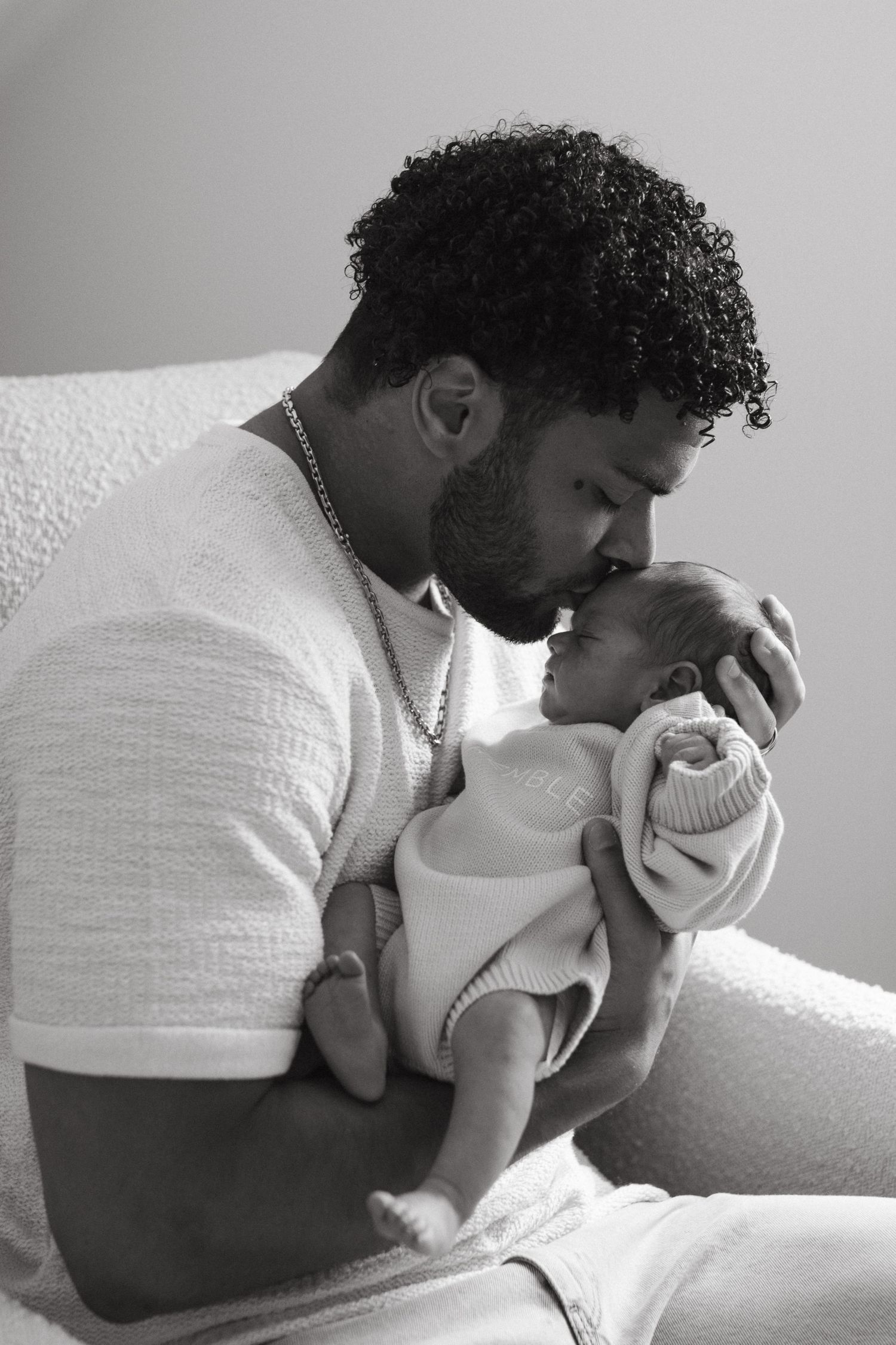 NFL player from the Carolina Panthers cradling his newborn in a candid family moment