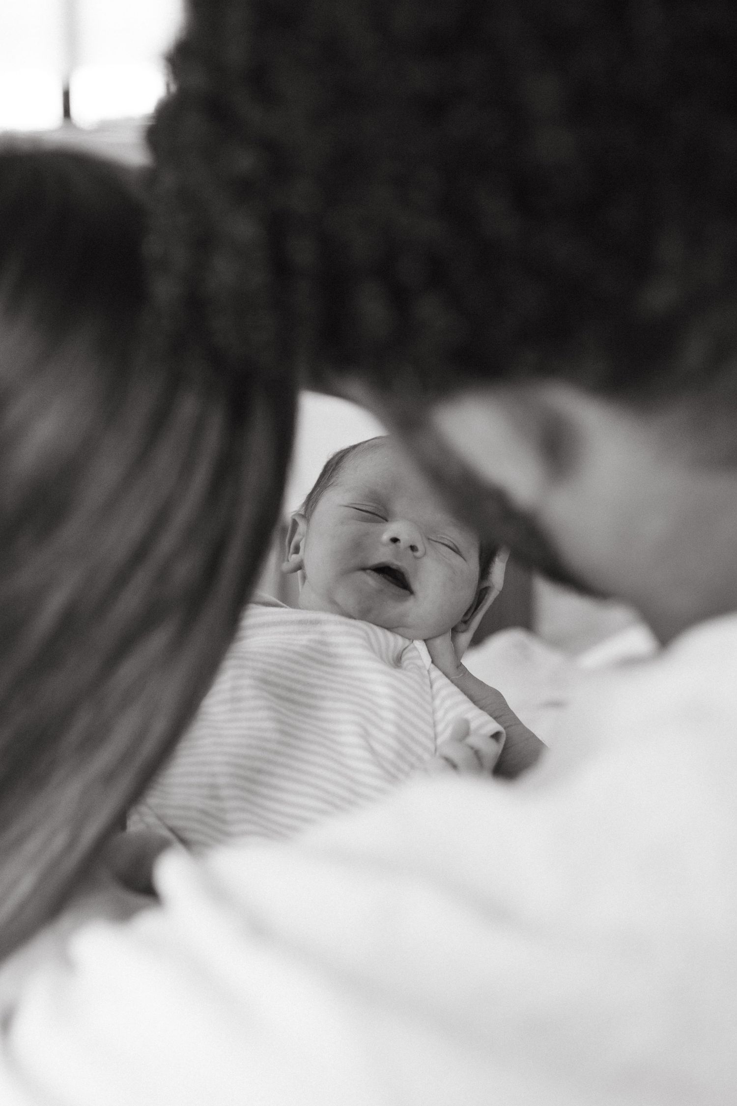 Parents holding their newborn baby during an in-home newborn session