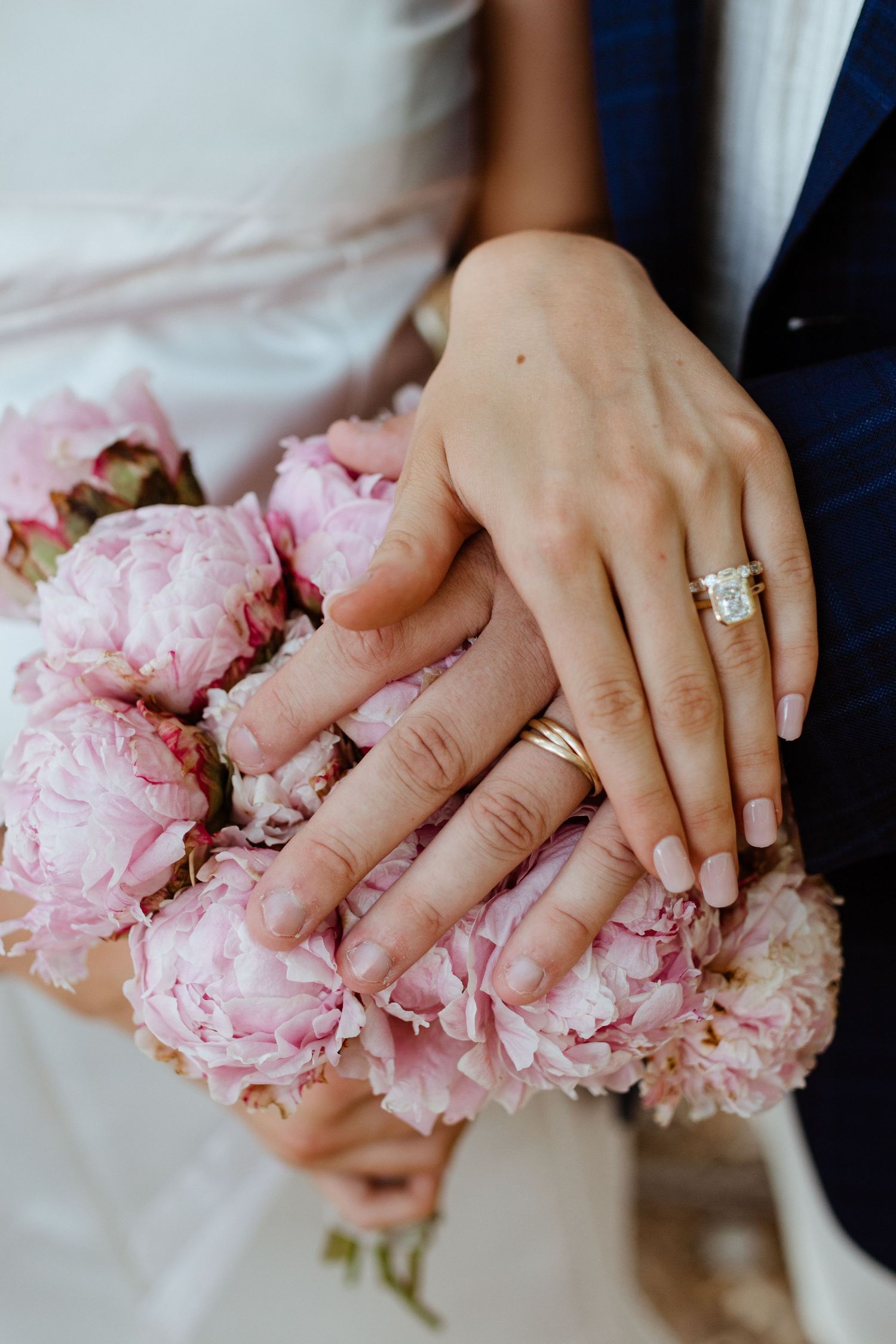 Close-up of bride and groom wedding rings on top of bouquet