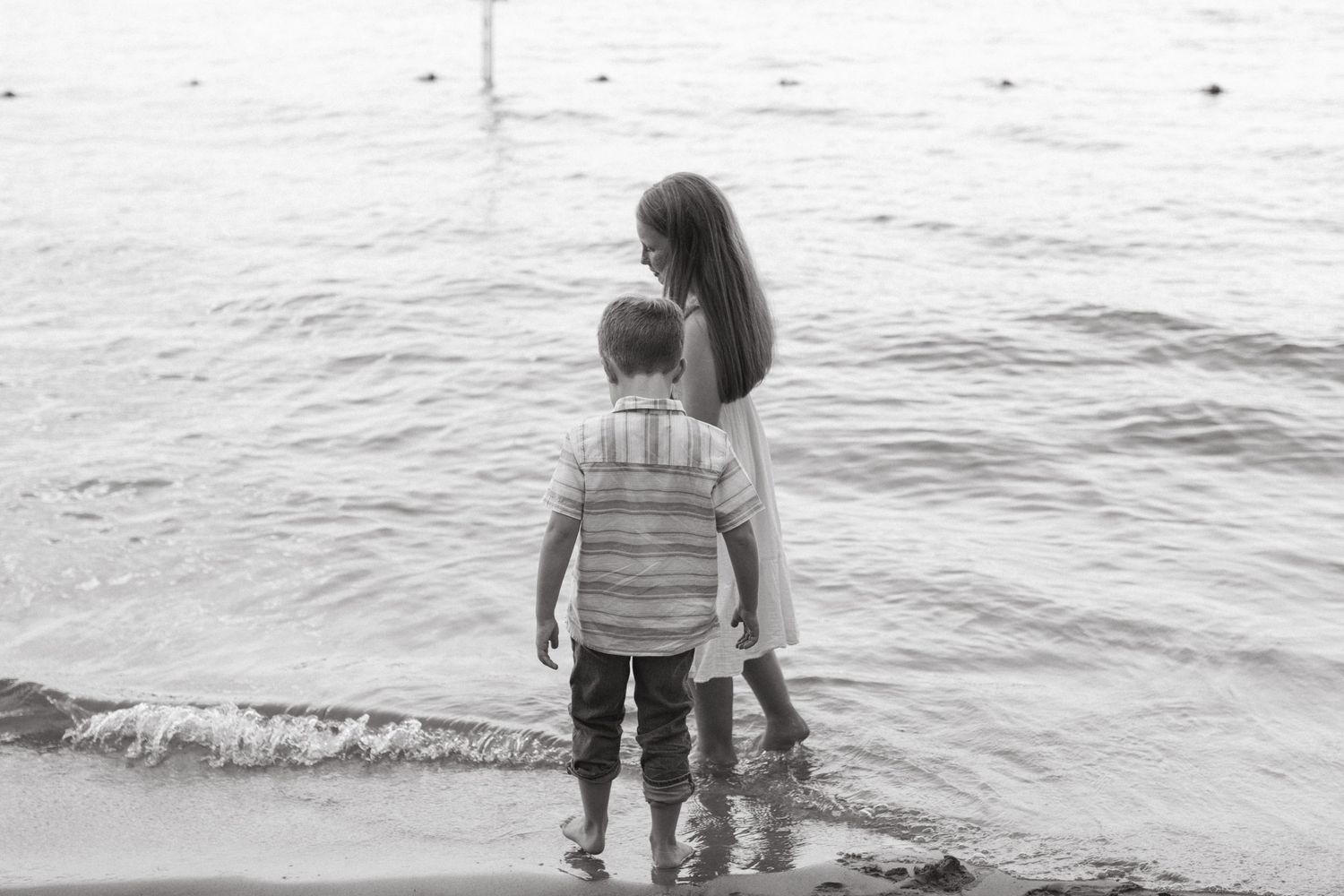 siblings walking along lake shore in rock hill