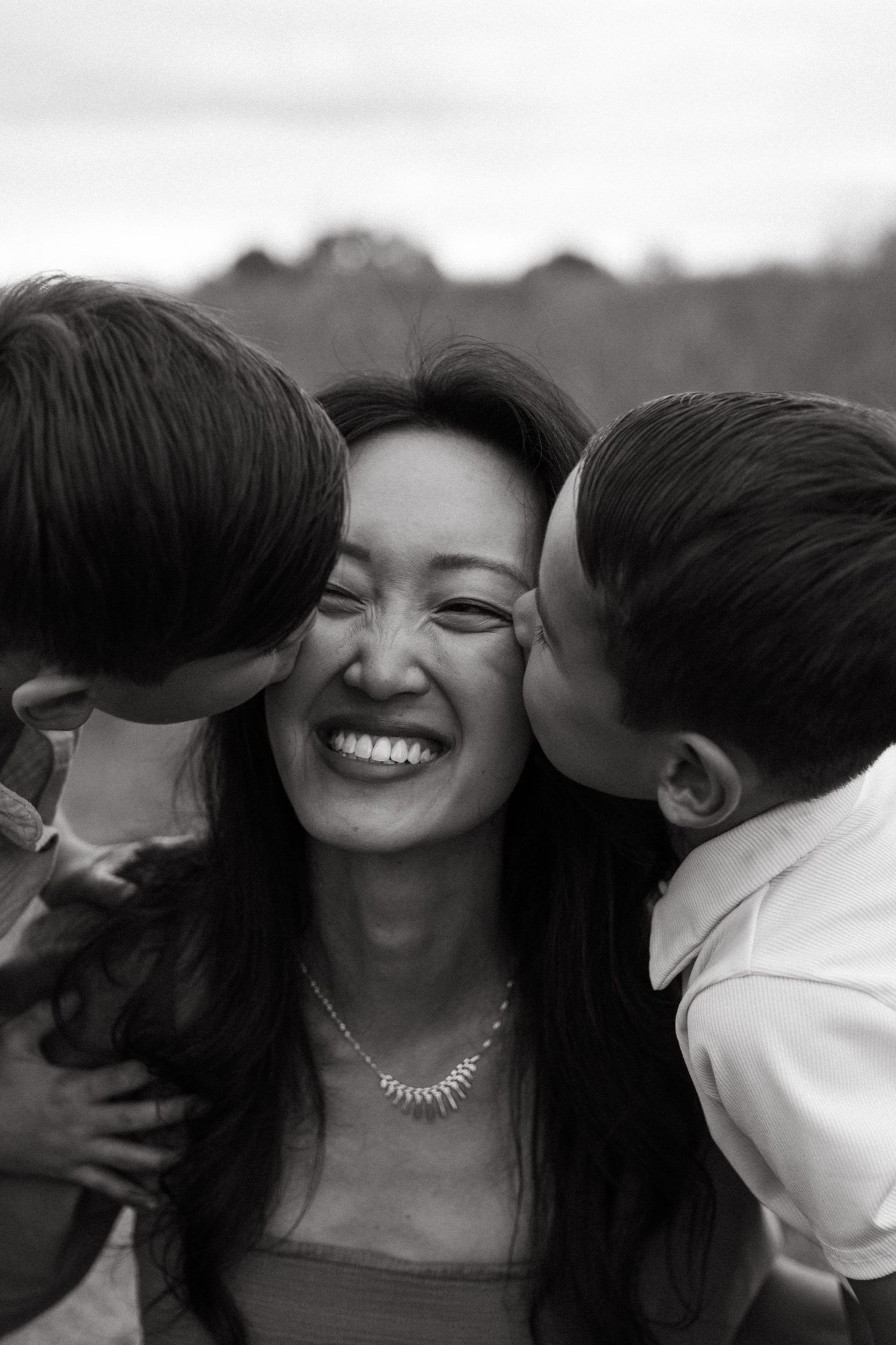 boys kissing mothers face during a family session