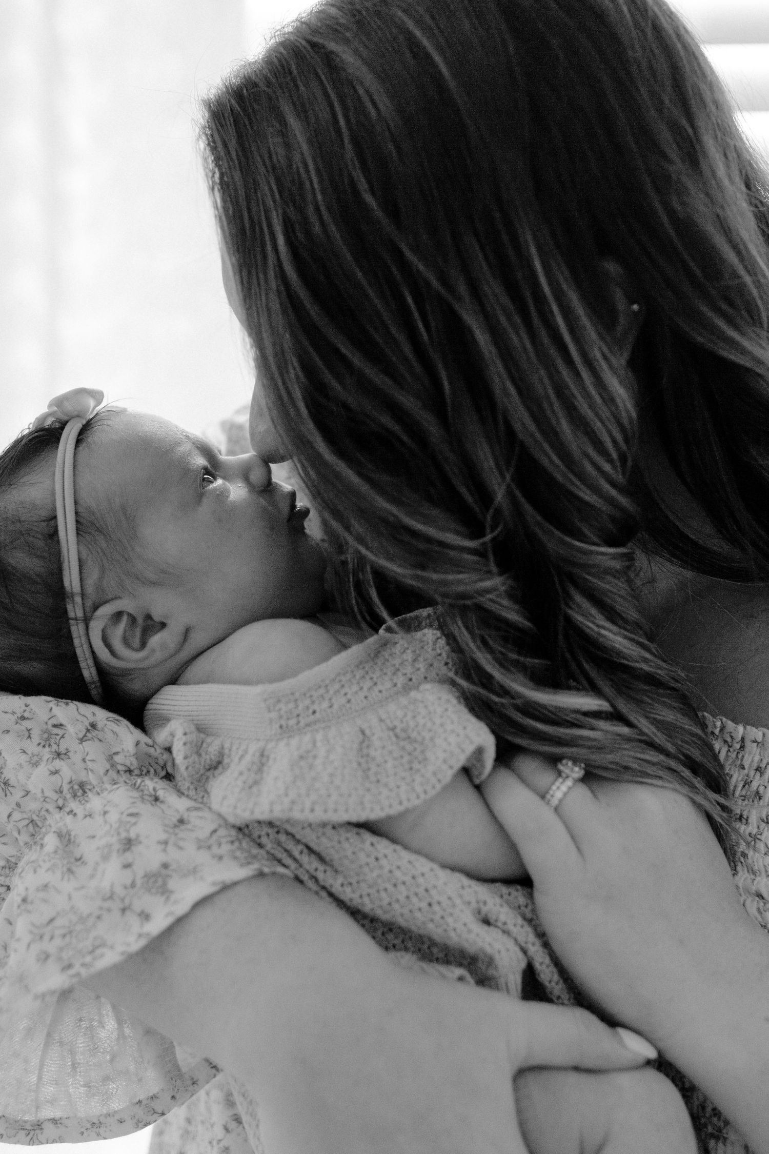 Mother gently holding her baby during a lifestyle newborn session