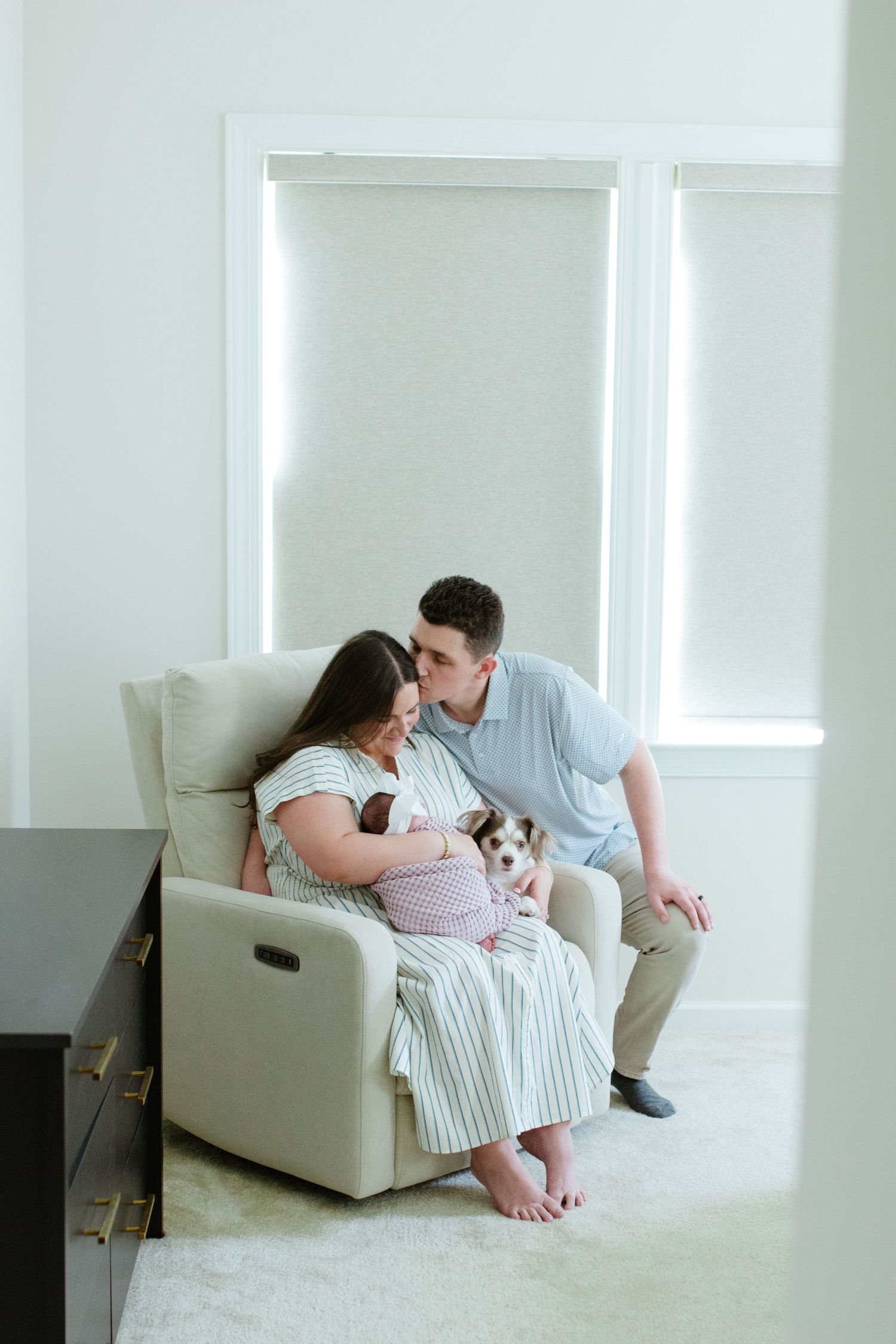 in-home newborn session of a family holding their new baby and dog in rock hill sc