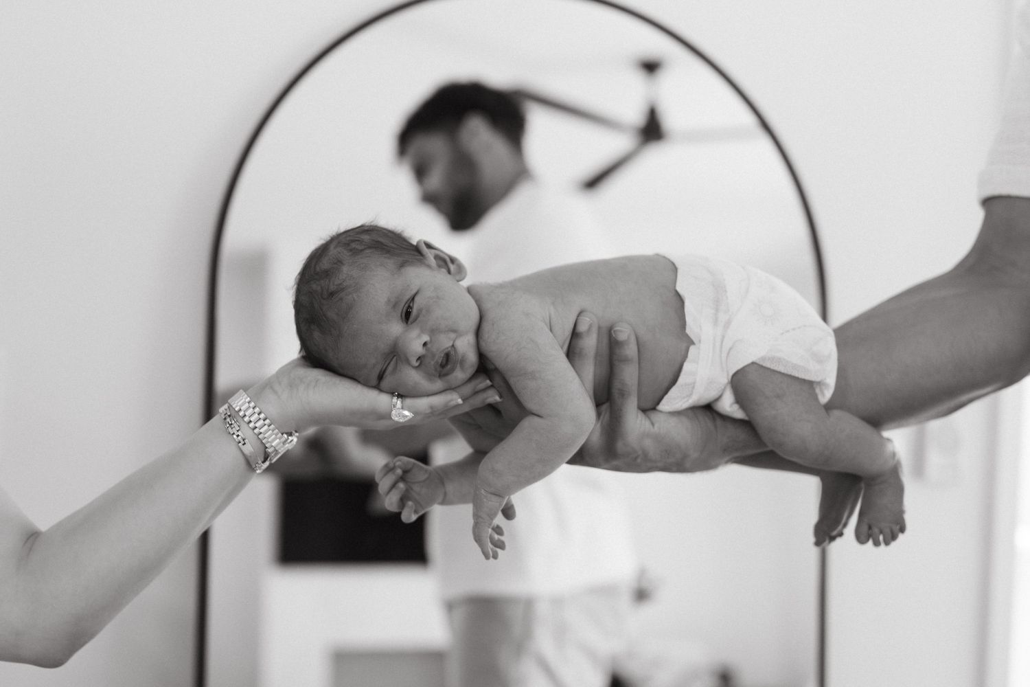 newborn session of Parents holding their newborn baby