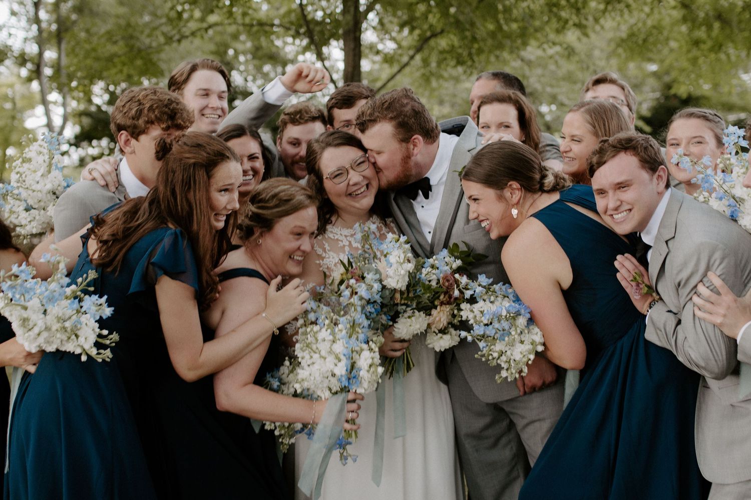 Bride and groom posing with bridesmaids and groomsmen outdoors