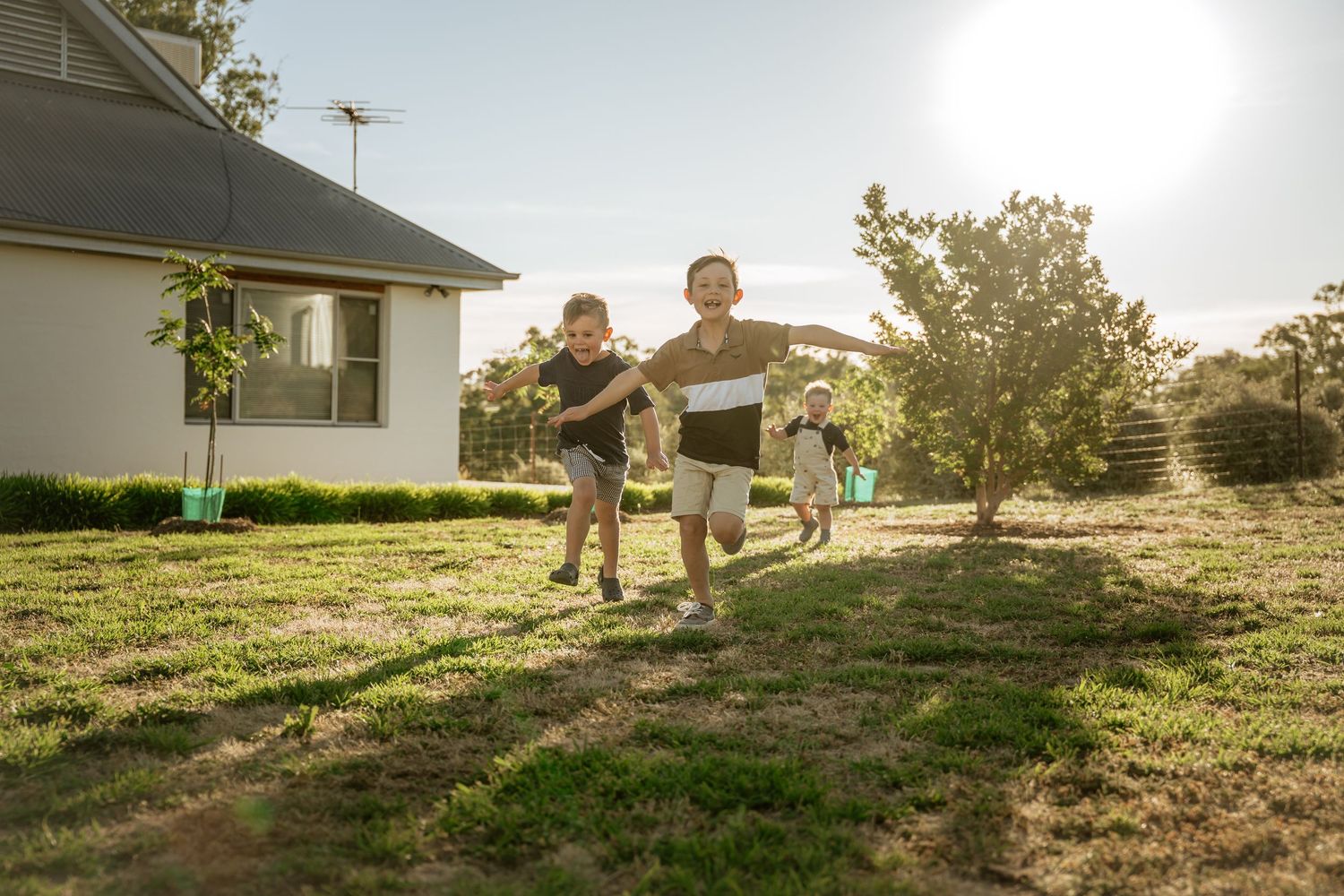 Three brothers running race pretending to be an airplane