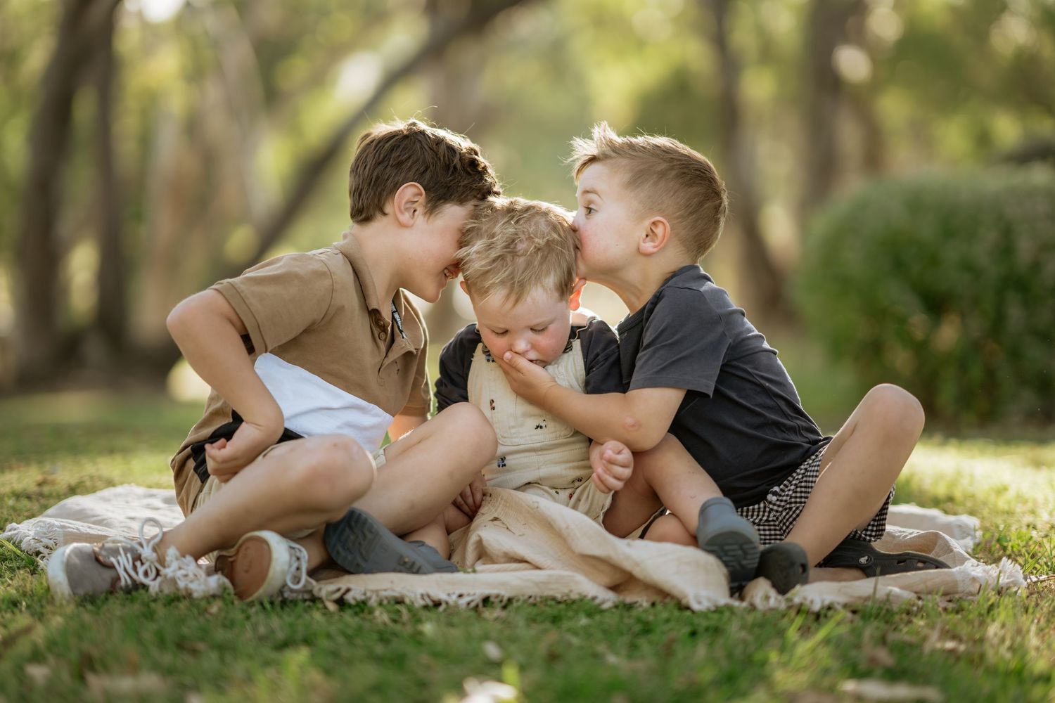 Brothers kissing littlest brother