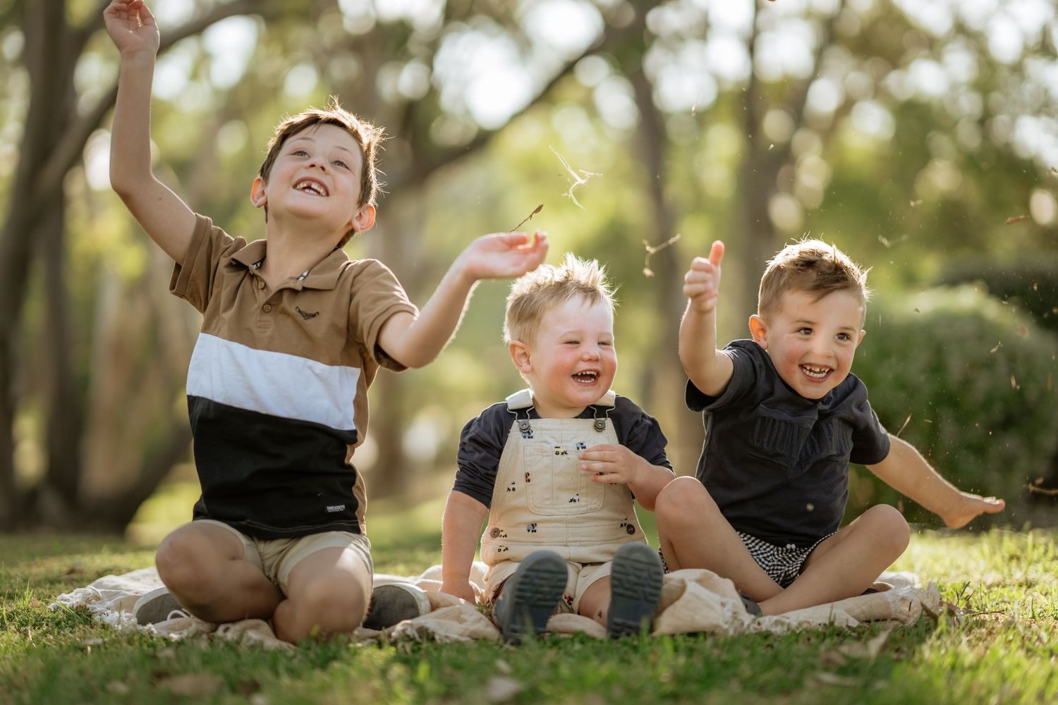 Three brothers throwing grass together