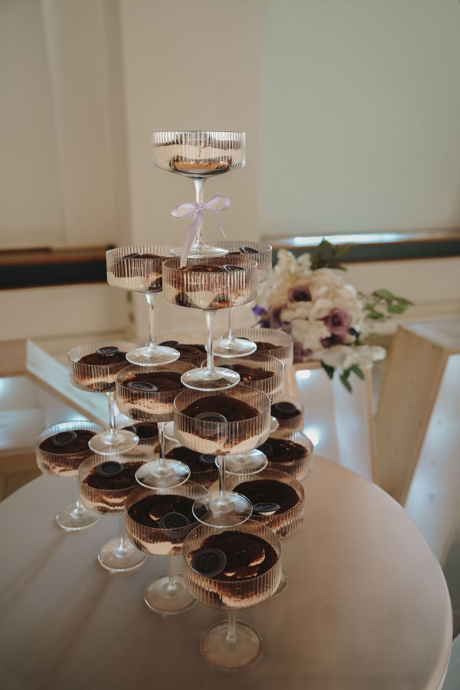 Elegant champagne tower with chocolate cupcakes arranged in tiers at a wedding reception.