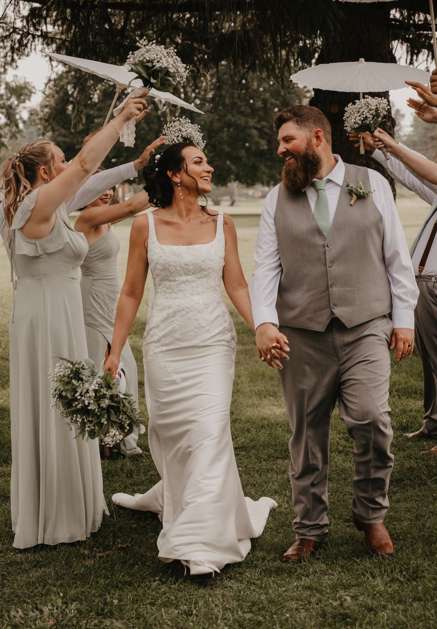 a bride and groom walking down an aisle with the bridal party